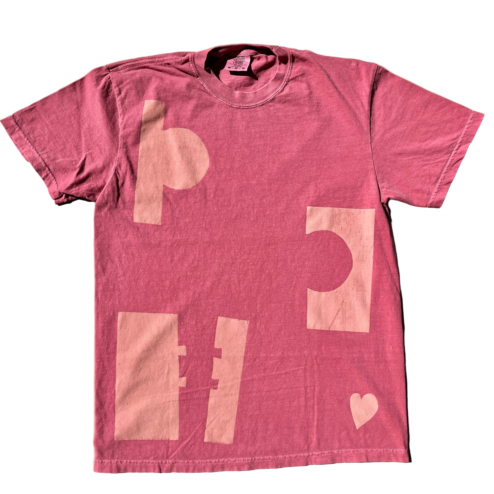 Pink t-shirt with abstract designs on a beige background